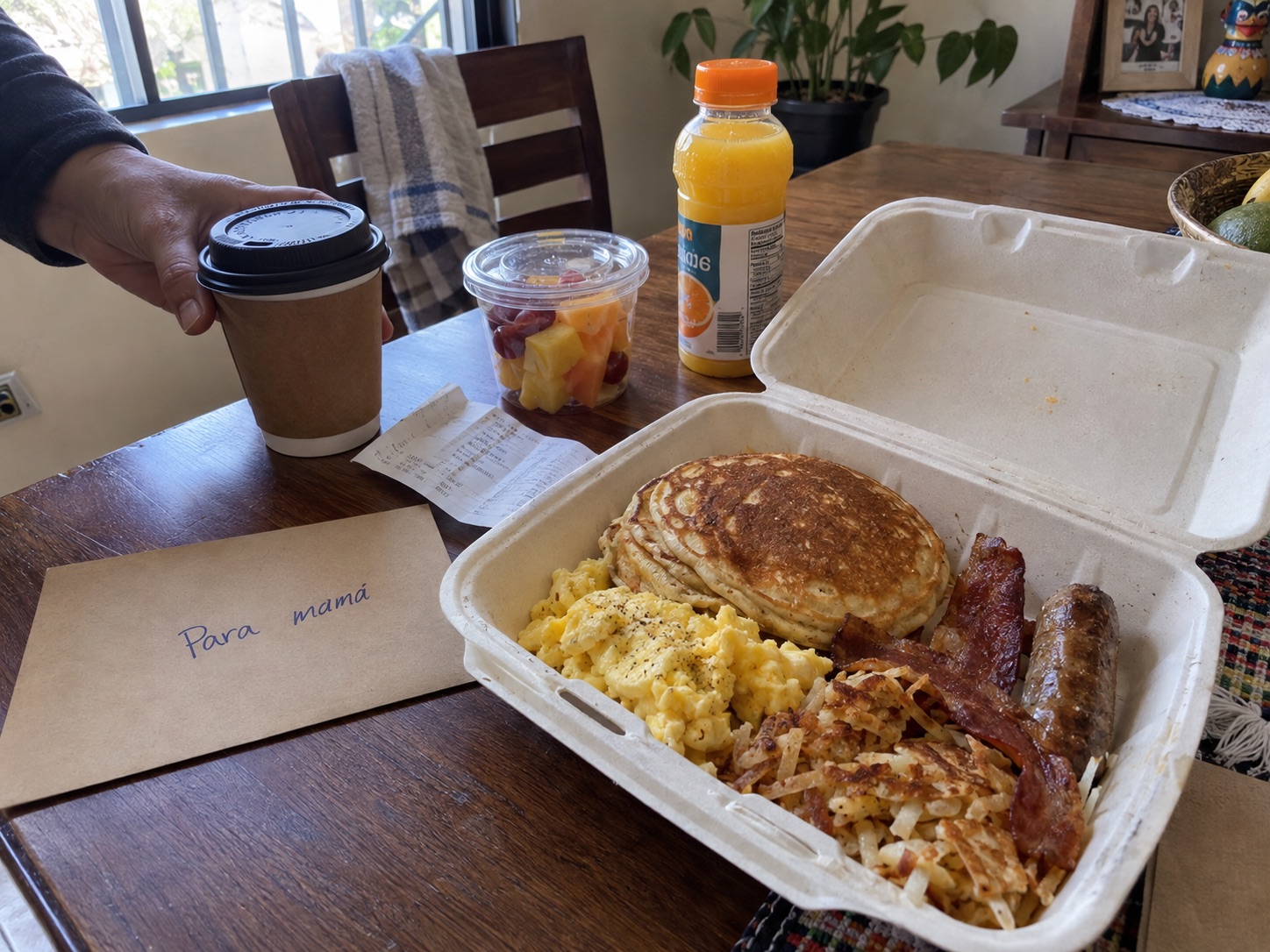 Breakfast plate with pancakes, eggs, bacon, sausage, fruit, coffee, and orange juice